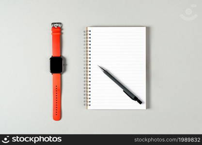 Notepad, orange watch, pen isolated on light gray background. Notepad with copy space. Office, business, discreet style.. Notepad, orange watch, pen isolated on light gray background. Notepad with copy space. Office, business, discreet style