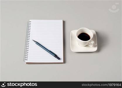 Notepad, pen and a cup of coffee isolated on light gray background. Notepad with copy space. Office, business, discreet style. Notepad, pen and a cup of coffee isolated on light gray background. Notepad with copy space. Office, business, discreet style.