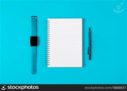 Notepad, watch, pen isolated on light blue background. Notepad with copy space. Office, business, discreet style. Notepad, watch, pen isolated on light blue background. Notepad with copy space. Office, business, discreet style.