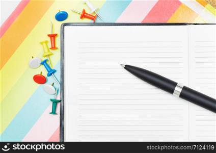 Notepad with pen and pushpins. Close-up photo
