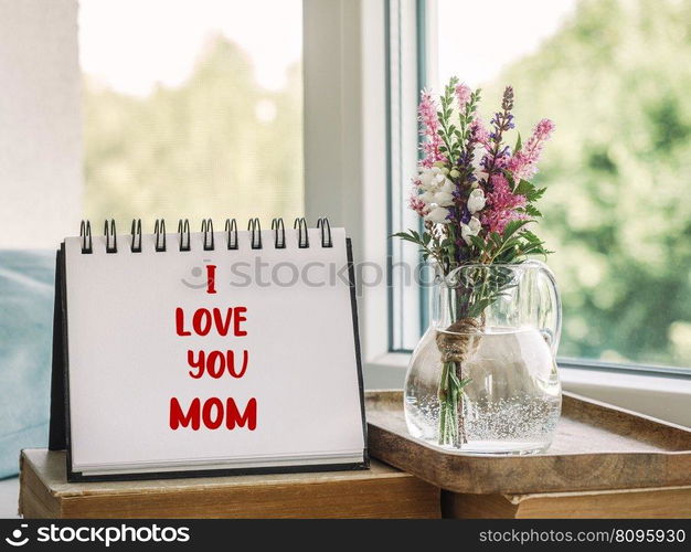 Notepad with the word MOM. Closeup, indoors. Congratulations for family, loved ones, friends and colleagues. Notepad with the word MOM. Closeup, indoors