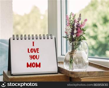 Notepad with the word MOM. Closeup, indoors. Congratulations for family, loved ones, friends and colleagues. Notepad with the word MOM. Closeup, indoors