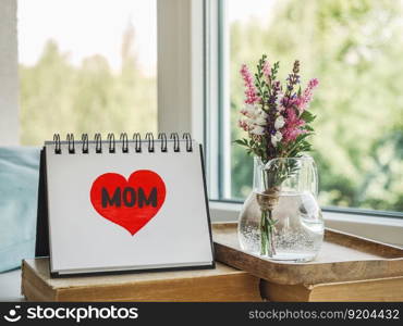 Notepad with the word MOM. Closeup, indoors. Congratulations for family, loved ones, friends and colleagues. Notepad with the word MOM. Closeup, indoors