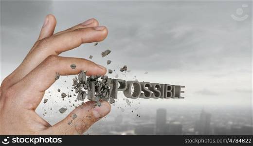 Nothing is impossible. Close view of male hand taking with fingers word impossible