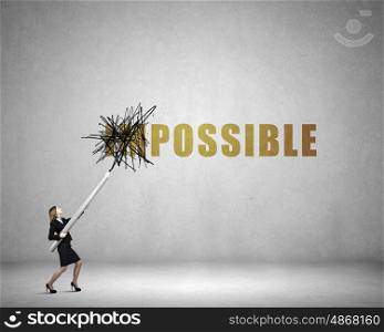 Nothing is impossible. Young businesswoman with huge pencil changing word impossible