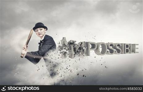 Nothing is impossible. Young woman crashing word impossible with baseball bat