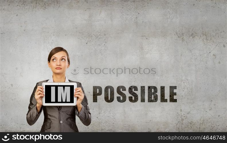 Nothing is impossible. Young woman holding tablet pc with word