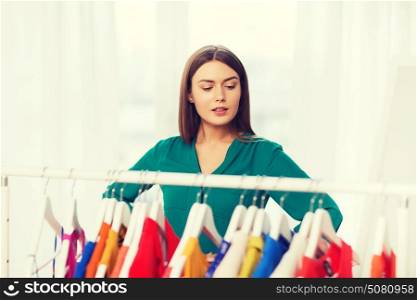 nothing to wear, clothing, fashion and style concept - woman choosing clothes at home wardrobe. woman choosing clothes at home wardrobe