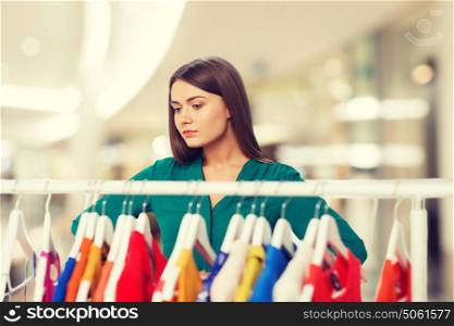 nothing to wear, clothing, sale, fashion and style concept - woman choosing clothes at shopping center or mall. woman choosing clothes at home wardrobe