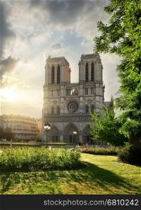 Notre Dame de Paris and green meadow at sunrise, France