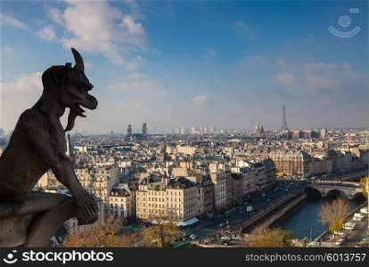 Notre Dame of Paris: Famous Chimera (demon) overlooking the Eiffel Tower at a summer day