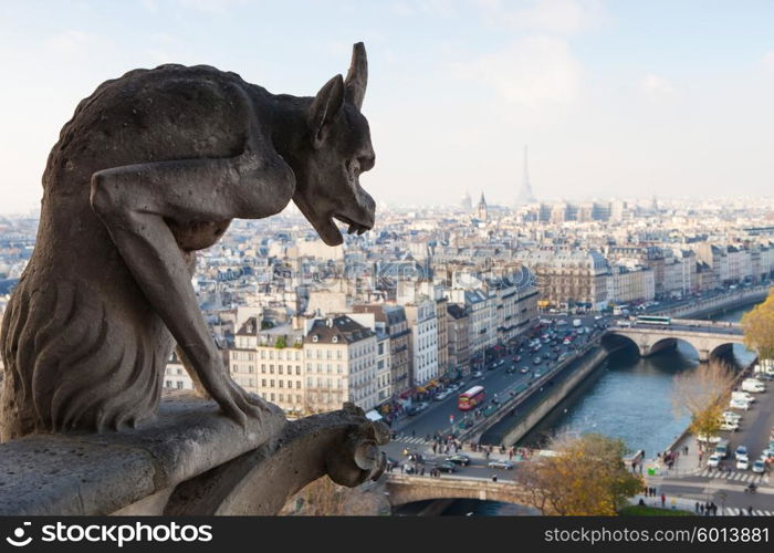 Notre Dame of Paris: Famous Chimera (demon) overlooking the Eiffel Tower at a summer day