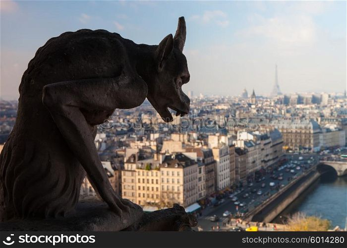 Notre Dame of Paris: Famous Chimera (demon) overlooking the Eiffel Tower at a summer day