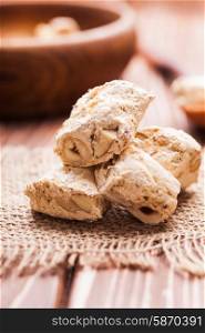 Nougat , typical italian dessert with nuts on a rustic table