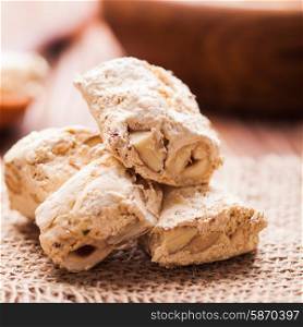 Nougat , typical italian dessert with nuts on a rustic table