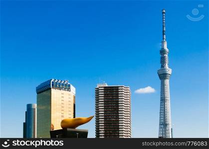 NOV 29, 2018 Tokyo, Japan - Tokyo Skytree Tower rised high against blue sky with Asahi Beer Hall in winter shot from Asakusa area, Japan famous modern landmark and cityscape