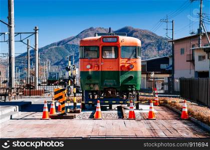 NOV 30, 2018 Shimoyoshida, Japan - Shimoyoshida blue train terrace with old classic commuter train with mountain view in background on bright blue sky day