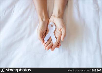 November Lung Cancer Awareness month, democracy and international peace day. Man holding white Ribbon on white background