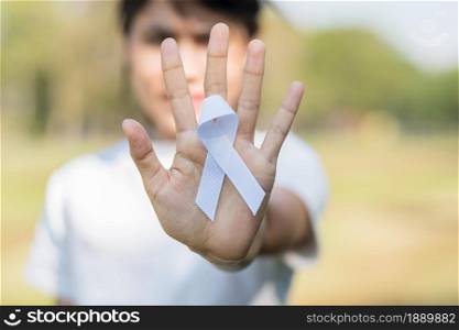 November Lung Cancer Awareness month, democracy and international peace day. Woman holding white Ribbon