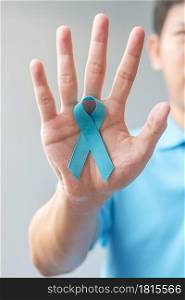 November Prostate Cancer Awareness month, Man in blue shirt with hand holding Blue Ribbon for supporting people living and illness. Healthcare, International men, Father and World cancer day concept