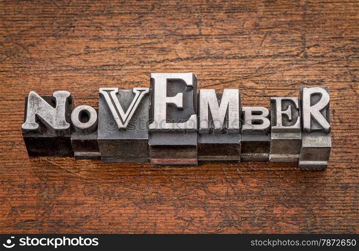November word in mixed vintage metal type printing blocks over grunge wood