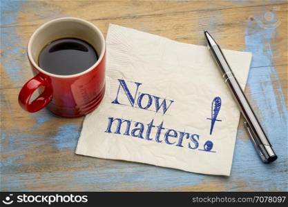 Now matters inspiration reminder - handwriting on a napkin with a cup of espresso coffee