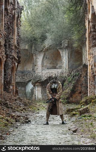 Nuclear post-apocalypse. Sole survivor in tatters and gas mask on the ruins of the destroyed city. Nuclear post-apocalypse survivor