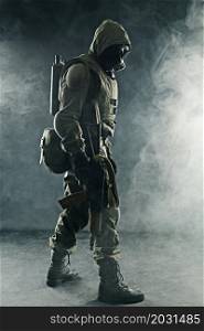 Nuclear post apocalypse. Studio shot of survivor with weapons and gas mask. Studio shot nuclear survivor with weapons