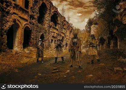 Nuclear post-apocalypse. Survivors in tatters and gas mask on the ruins of the destroyed city. Nuclear post-apocalypse survivors