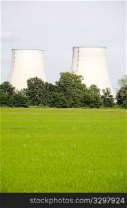 nuclear power station in rural area; vertical composition, large copy-space at the bottom; daylight.