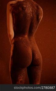 Nude back of woman covered in brown
