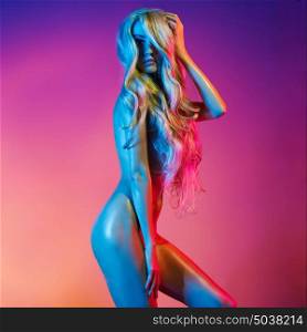 Nude beautiful blonde dancing in colorful light. Erotic portrait of sexy woman with long hairs.