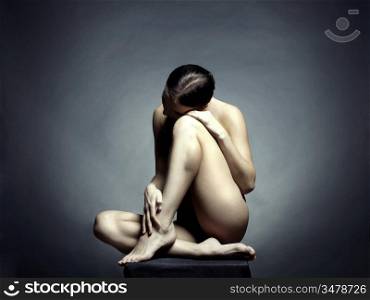 Nude beautiful sitting lady on black background