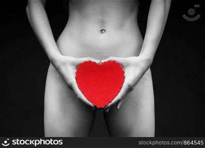 Nude body of a female in artistic concept holding red heart in her hands.