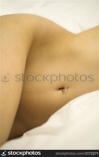 Nude Caucasian female body with pierced belly button.