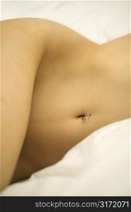 Nude Caucasian female body with pierced belly button.