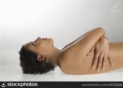 Nude Caucasian young adult woman lying on back looking up.