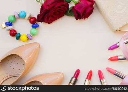 Nude colored high heels shoes with lipsticks and wallet hero header. Nude colored high heels still life