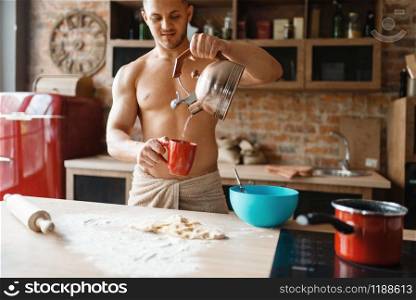 Nude man cooking romantic dinner on the kitchen. Naked male person preparing breakfast at home, food preparation without clothes