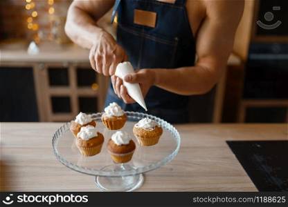 Nude man in apron cooking dessert on the kitchen. Naked male person preparing breakfast at home, food preparation without clothes. Nude man in apron cooking dessert on the kitchen
