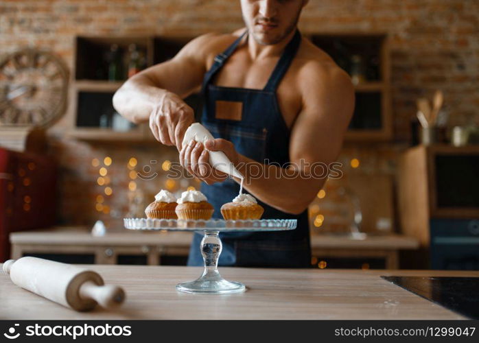 Nude man in apron cooking dessert on the kitchen. Naked male person preparing breakfast at home, naked food preparation. Nude man in apron cooking dessert on the kitchen