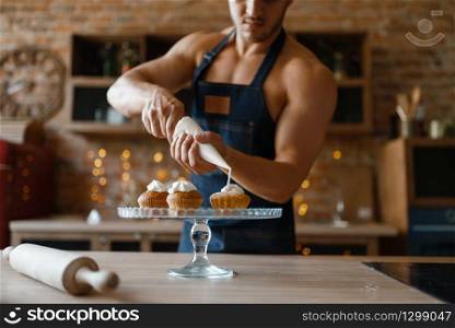 Nude man in apron cooking dessert on the kitchen. Naked male person preparing breakfast at home, naked food preparation. Nude man in apron cooking dessert on the kitchen