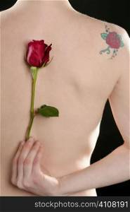 Nude woman back with red rose and flower tatoo