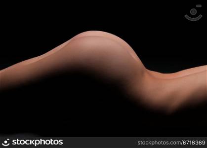 Nude woman&rsquo;s torso in deep shadow