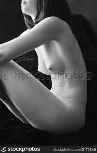 Nude young adult Caucasian female body sitting.