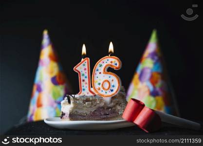 number 16 birthday lighted candle slice cake with party hat party horn blower