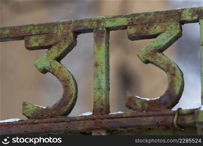Number 33 on gate. Decoration on a fence. Exterior