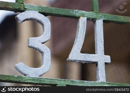 Number 34 on gate. Decoration on a fence. Exterior