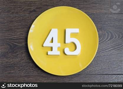 Number forty five on the yellow plate and brown background.. Number forty five on the yellow plate.