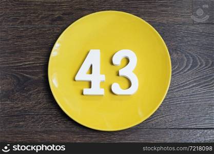 Number forty three on the plate yellow and brown background.. Number forty three on the yellow plate.